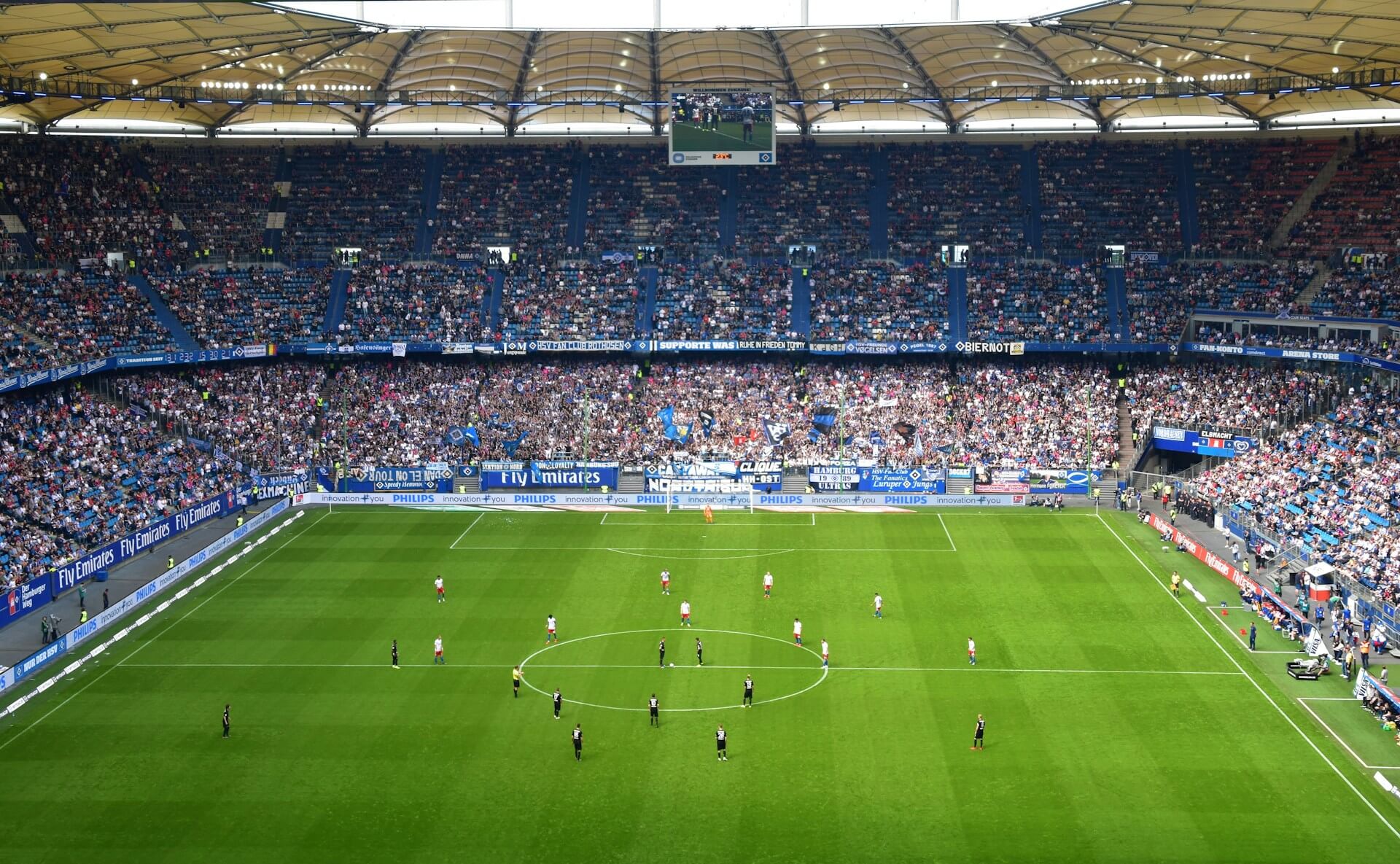 Auf dem Spielfeld findet ein spannendes Fußballspiel in einem vollen Stadion statt.